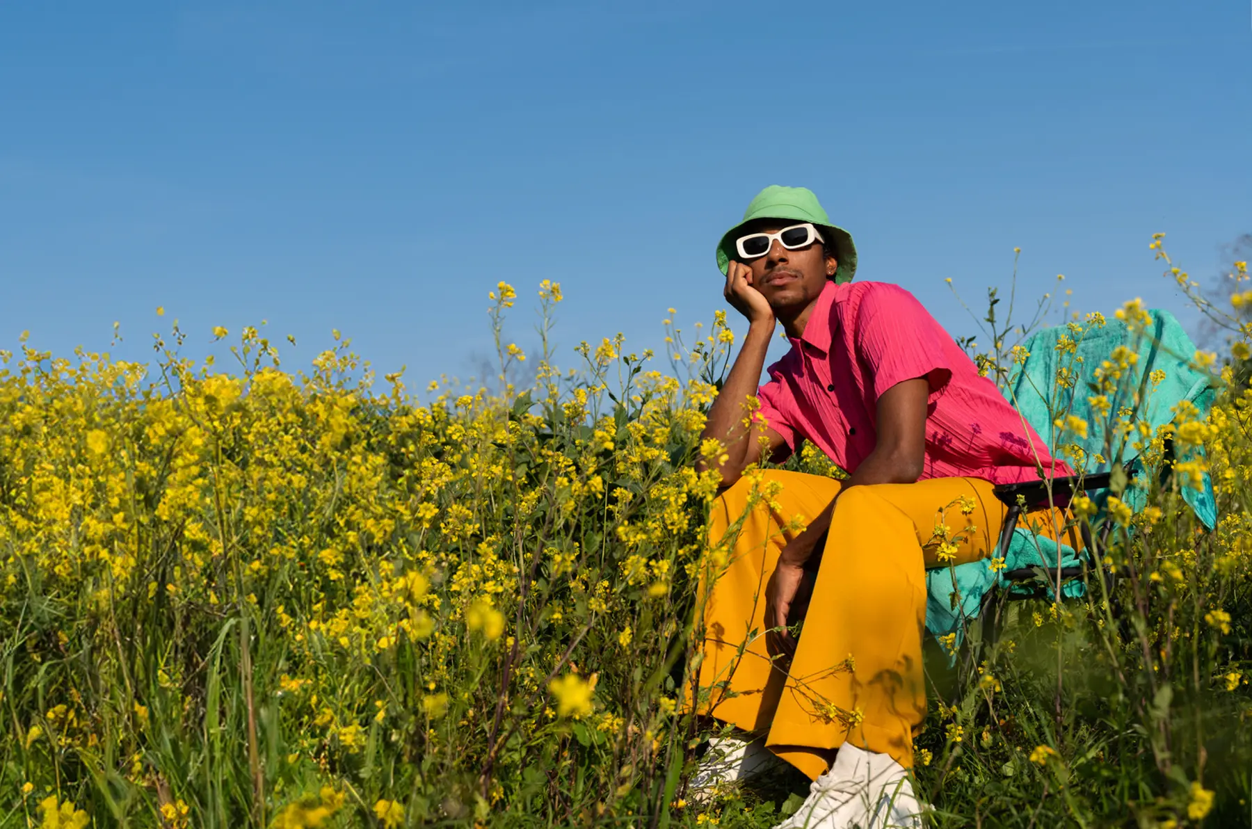 Person entspannt an einem sonnigen Sommertag in einer Blumenwiese